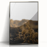Mid-century modernist art depicting abstract fall foliage in warm orange and brown tones, framed in silver acrylic.