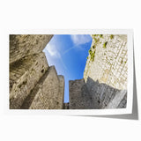 Rolled print showcasing a vibrant landscape of a majestic castle surrounded by lush greenery, presented in a protective cardboard tube, ideal for home décor.