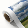 Rolled canvas showcasing a vibrant landscape design with a rustic barn, featuring rich colors and intricate details, securely packaged in a protective tube for easy transport.