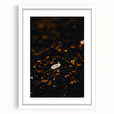 Abstract art print depicting autumn leaves in warm orange and red tones on a white framed canvas.