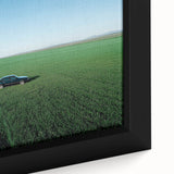 Close-up of a framed canvas print depicting a vibrant countryside landscape with rolling hills, lush greenery, and a serene blue sky, perfect for home decor.