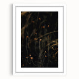 Abstract art print of autumn leaves in warm orange and red tones, framed in white, ideal for dining room decor.