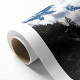 Rolled canvas depicting a vibrant landscape bridge design, showcasing intricate details and rich colors, securely packaged in a protective cardboard tube for safe shipping.
