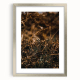 Textured abstract art print depicting fall colors in muted oranges and browns on a framed silver mat, ideal for bedroom art.