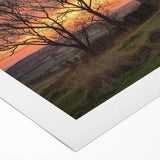Rolled canvas displaying a picturesque landscape of a rustic barn surrounded by vibrant fields, securely packaged in a durable cardboard tube for safe transport.