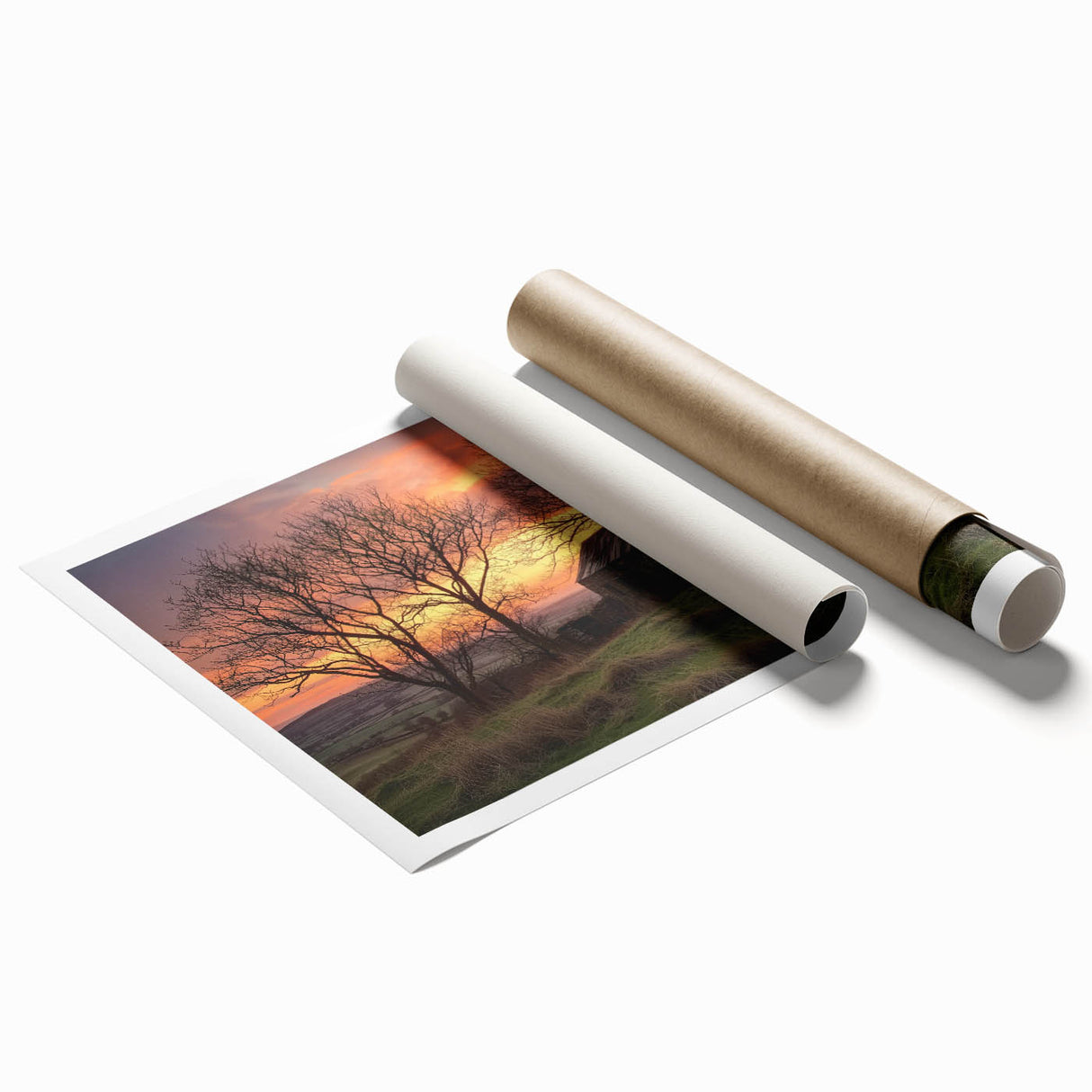 Landscape barn print featuring a rustic red barn surrounded by vibrant green fields under a blue sky, rolled securely in a protective cardboard tube for safe shipping.
