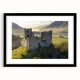 Elegant black-framed landscape artwork depicting a majestic castle surrounded by lush greenery, featuring a white mat for an enhanced presentation. Perfect for home decor.