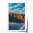 Stunning rolled print of a dramatic coastal landscape featuring towering cliffs and vibrant blue skies, ideal for home decor or artistic display.