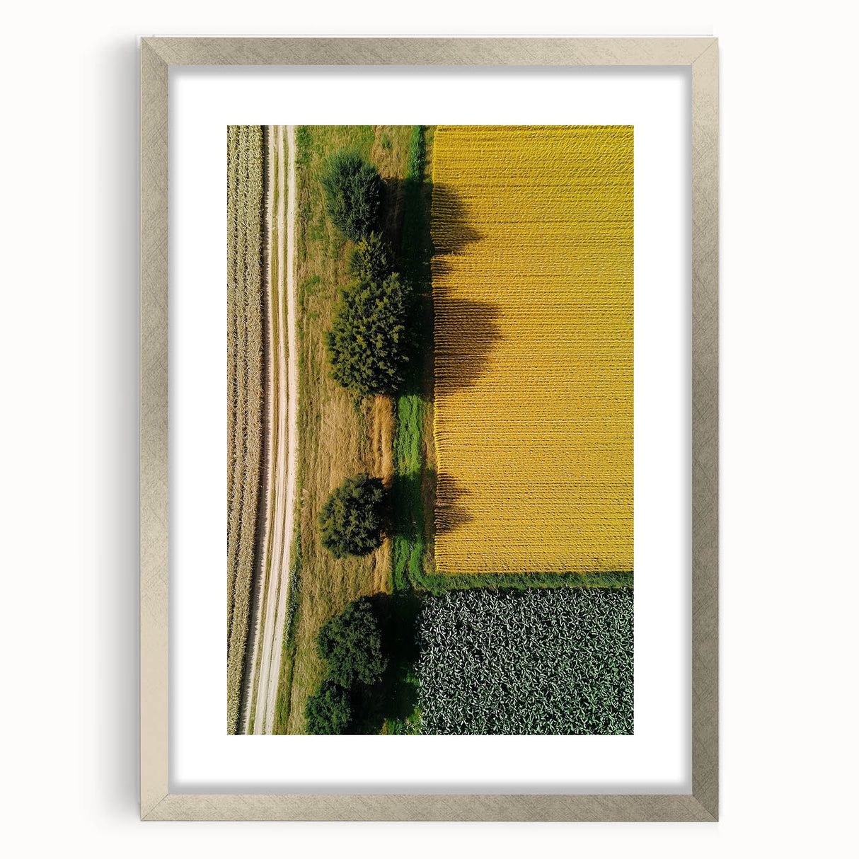 Silver-framed landscape artwork featuring a serene countryside scene, elegantly matted for depth and style, ideal for enhancing home decor aesthetics.