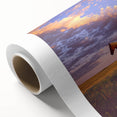 Rolled canvas artwork showcasing a serene countryside landscape with vibrant green fields and a clear blue sky, elegantly packaged in a protective cardboard tube.