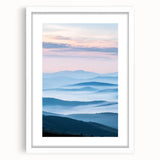 Framed landscape artwork depicting a serene countryside scene with lush greenery and soft clouds, presented in a white mat for an elegant finish, ideal for home decor.