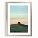 Silver-framed landscape artwork depicting a serene countryside scene with vibrant greenery and a clear sky, elegantly matted for added depth and style.