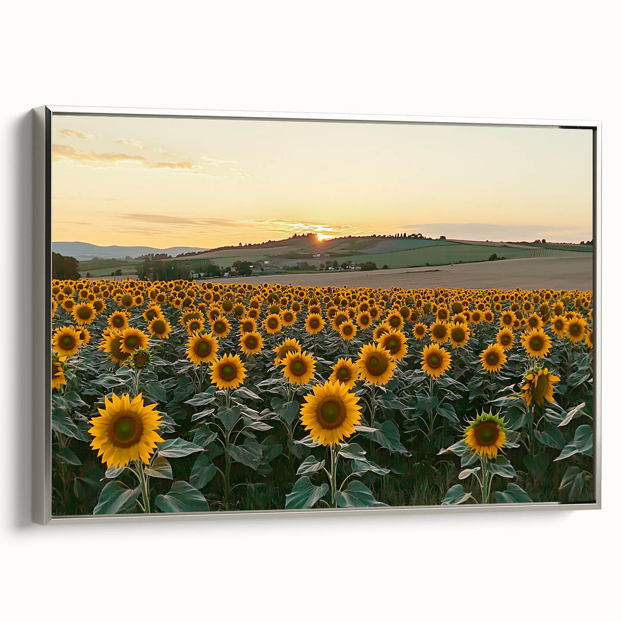 Framed canvas artwork depicting a serene countryside landscape, featuring lush green fields and a tranquil blue sky, with a sleek silver frame enhancing its elegance.