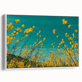 Framed canvas artwork depicting a serene countryside landscape with rolling hills, lush greenery, and a clear blue sky, presented in a sleek white frame. Ideal for home decor, this piece adds a touch of tranquility to any space.