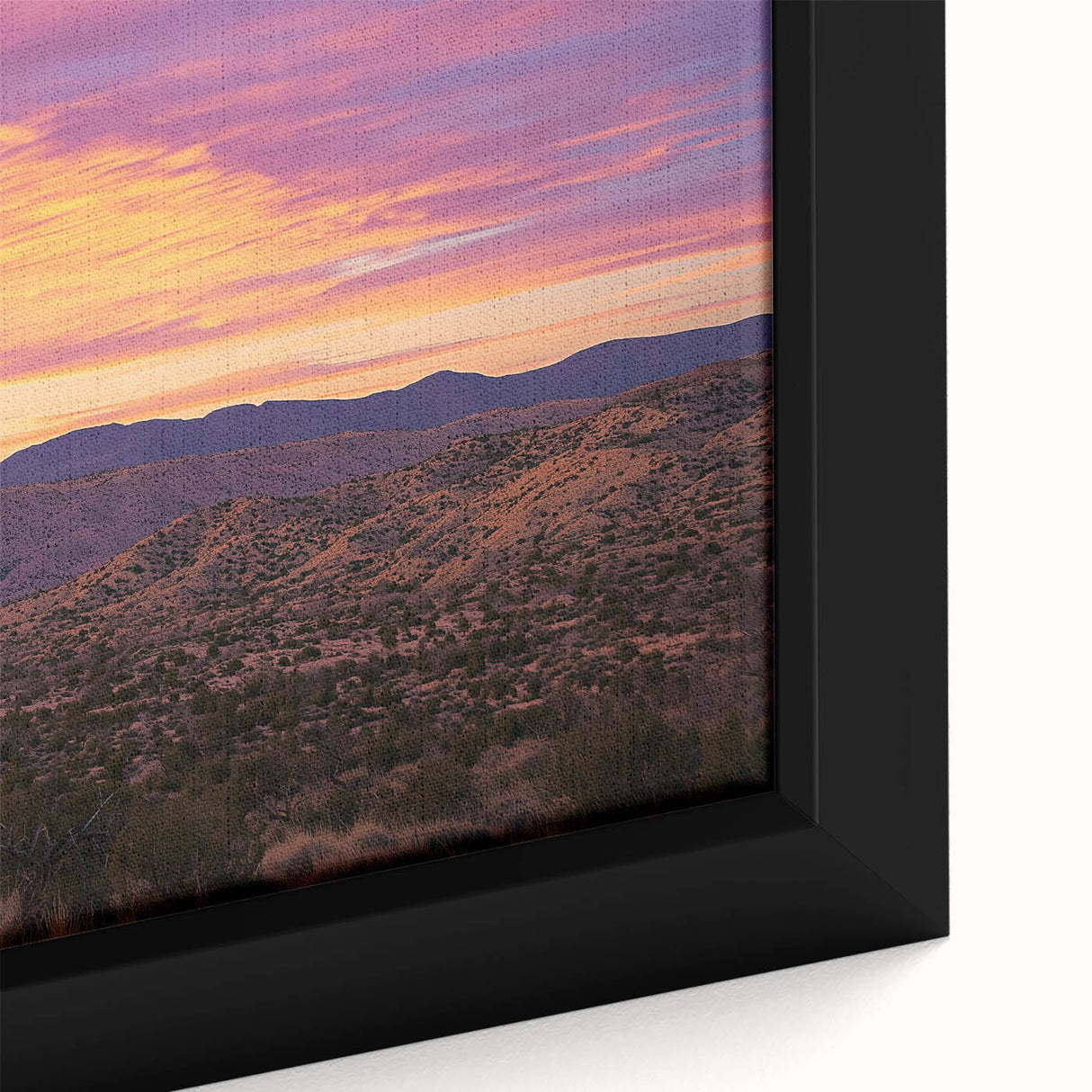 Close-up of a framed canvas print depicting a vibrant desert landscape, showcasing warm earthy tones and intricate details of sand dunes and cacti, perfect for home decor.
