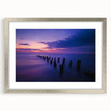 Framed landscape artwork depicting serene beach scenery with soft waves and a clear sky, enclosed in a modern silver mat for an elegant presentation.