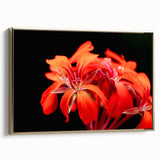 Framed wall art featuring a vibrant botanical geranium design on a textured canvas, accented with a gold frame, showcasing a side view for added depth.