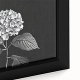 Close-up of a framed botanical wall art piece showcasing vibrant blue and lavender hydrangea flowers on a textured canvas, ideal for home decor.