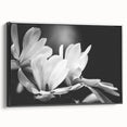 Framed canvas wall art showcasing a botanical magnolia design, featuring intricate floral details in soft pastel colors, set against a sleek black frame.
