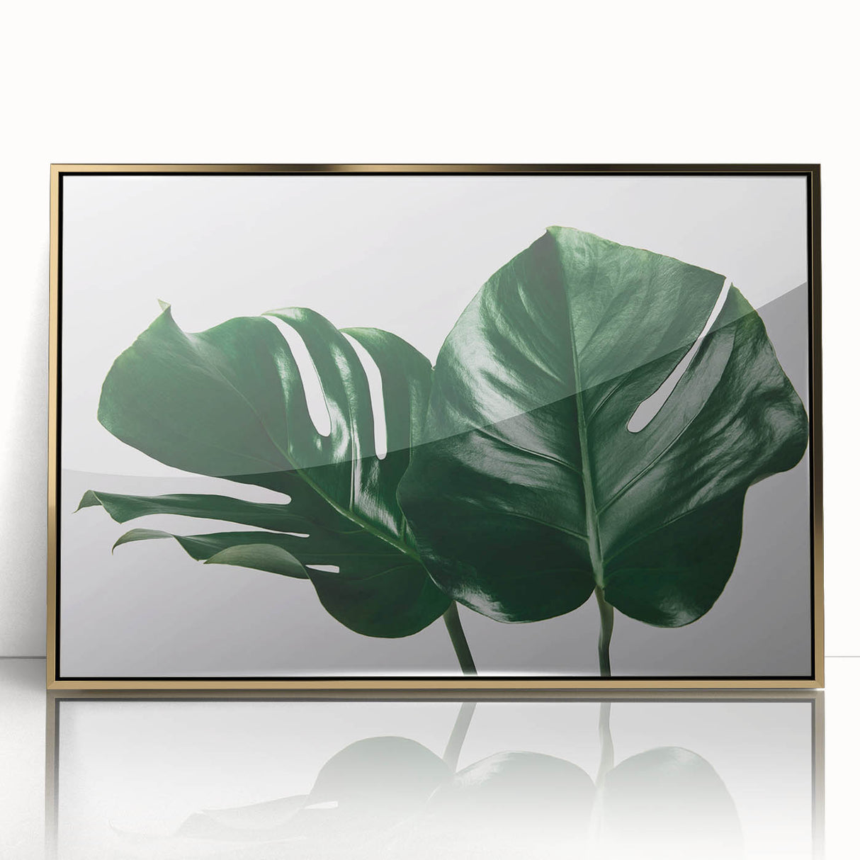 Framed wall art featuring a vibrant monstera plant design with botanical elements, set in an elegant gold frame, ideal for modern home decor.