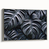 Framed canvas wall art featuring a vibrant botanical monstera design with silver detailing, displayed from the side in a stylish interior setting. Perfect for nature-inspired decor.