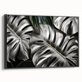 Framed wall art featuring a botanical monstera design on canvas, showcasing vibrant green leaves against a black background, ideal for modern home decor.
