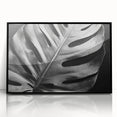 Framed wall art featuring a botanical monstera design in vibrant green and black, displayed in an acrylic frame, perfect for modern home decor.