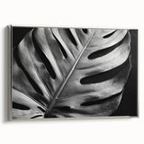 Framed canvas wall art featuring a botanical monstera design, showcasing vibrant green leaves against a silver frame, ideal for home decor enhancement.