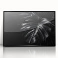 Framed wall art featuring a botanical Monstera design in vibrant greens and blacks, elegantly displayed in a sleek black frame, perfect for enhancing modern decor.