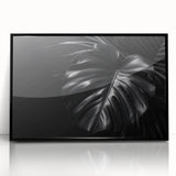 Framed wall art featuring a botanical Monstera design in vibrant greens and blacks, elegantly displayed in a sleek black frame, perfect for enhancing modern decor.