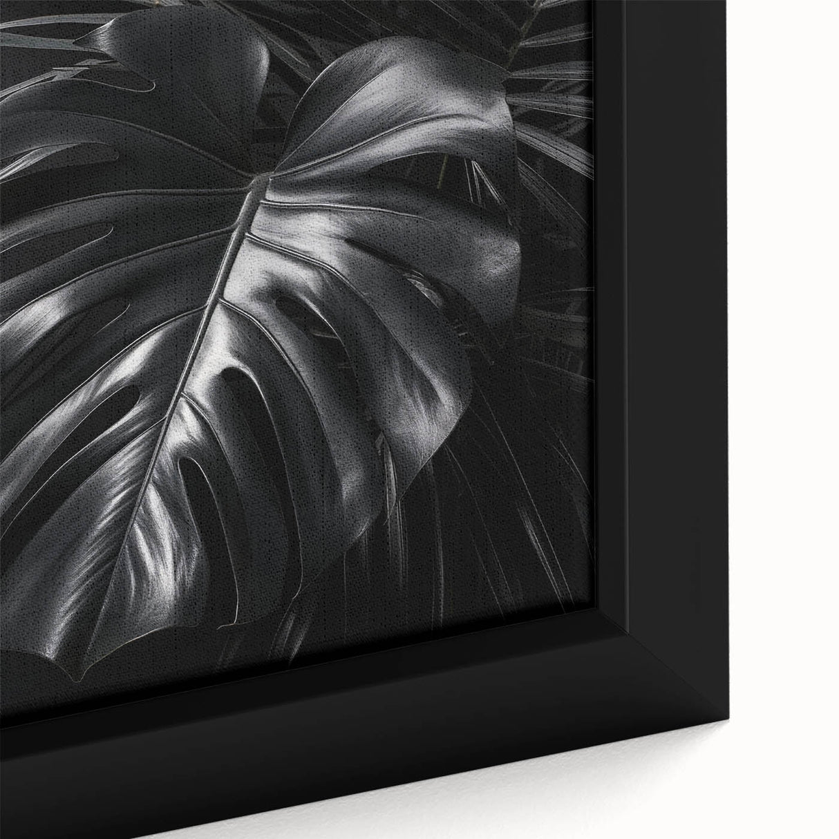 Close-up of a framed botanical wall art featuring a vibrant monstera leaf design on textured canvas, ideal for adding a tropical touch to home decor.