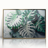 Framed wall art featuring a botanical monstera design with vibrant green leaves and a gold acrylic front, perfect for modern home decor.