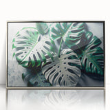 Framed botanical wall art featuring a Monstera design with vibrant green leaves, set in a sleek silver frame, perfect for enhancing modern home decor.