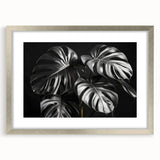 Botanical wall art collection featuring a silver-framed Monstera design, showcasing vibrant green foliage and elegant matting, perfect for home decor enhancement.