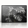 Framed wall art featuring a botanical monstera design in vibrant green tones, displayed against a sleek black frame, perfect for modern home decor and plant enthusiasts.
