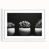 Framed botanical wall art featuring an elegant design of succulents in soft green and pink hues, displayed with a white mat, perfect for modern home decor.