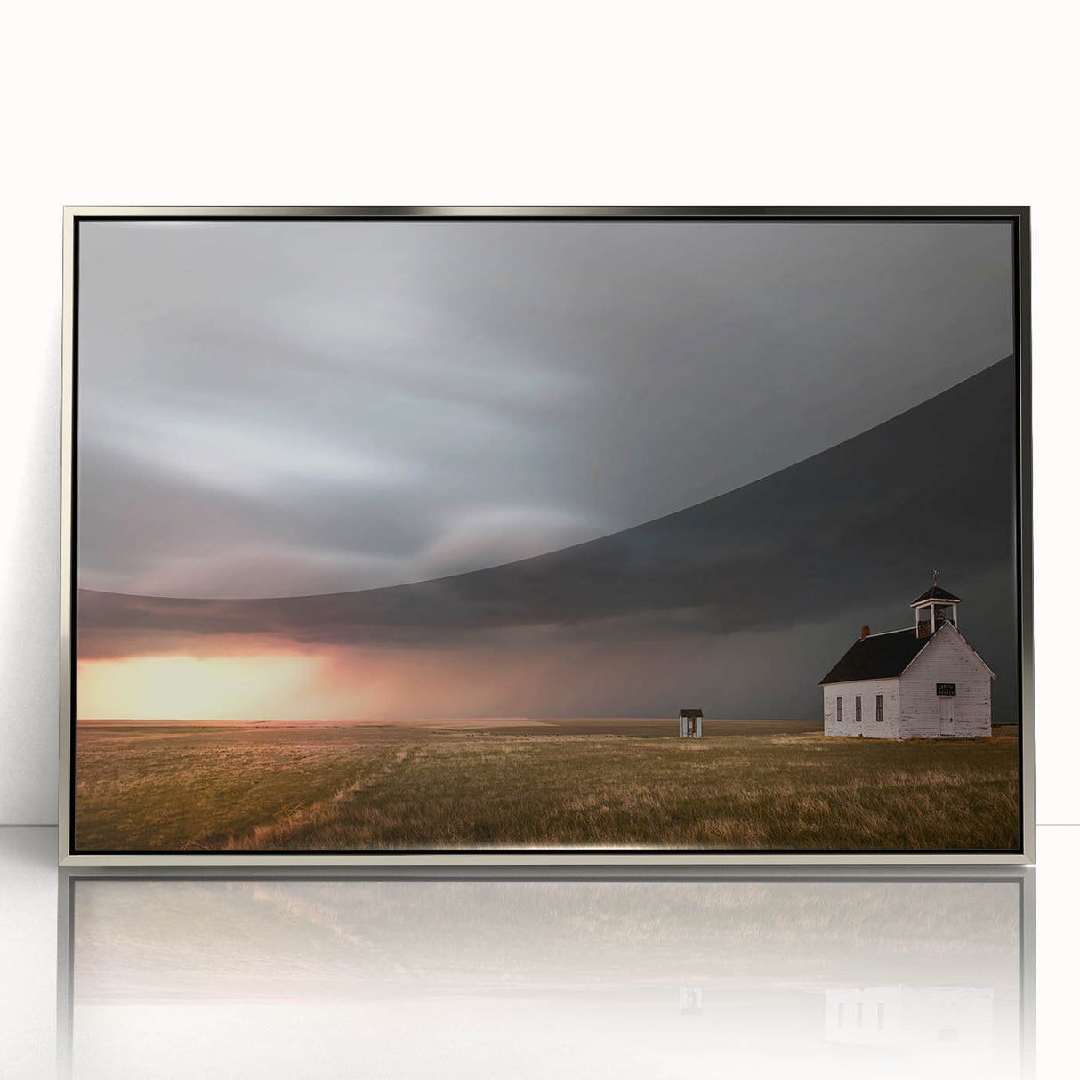 Framed wall art showcasing a serene landscape of a rustic barn, elegantly displayed with a silver acrylic frame, perfect for enhancing home decor.