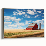 Framed canvas wall art showcasing a serene landscape with rustic barns under a bright blue sky, featuring silver accents in the frame for an elegant touch.
