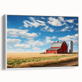 Framed canvas wall art showcasing a serene landscape with rustic barns, set against a vibrant blue sky; ideal for enhancing home decor with nature-inspired themes.