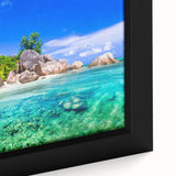 Framed canvas art featuring a vibrant beach landscape with turquoise waters and golden sands, showcasing a serene sunset over the horizon, perfect for coastal decor.