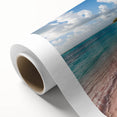 Vibrant rolled canvas artwork showcasing a serene beach landscape, featuring soft waves and a colorful sunset, ideal for home décor. Packaged securely for shipping.