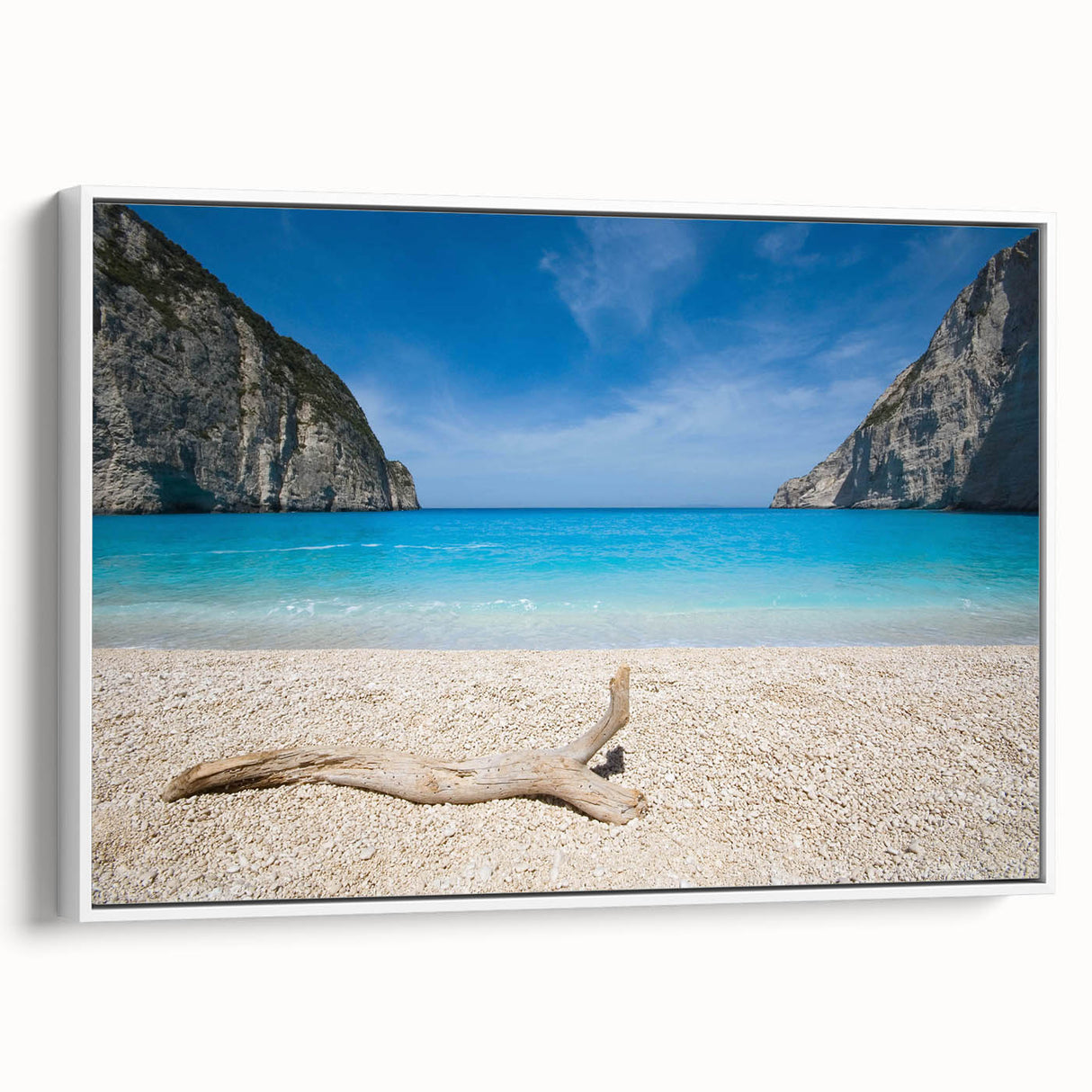 Framed canvas wall art showcasing a serene beach landscape with soft blue skies and gentle waves, elegantly displayed with a white frame, perfect for coastal-themed decor.