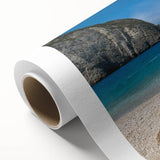 Vibrant rolled canvas artwork depicting a serene beach landscape with soft waves and clear blue skies, ideal for home decor and relaxation themes.