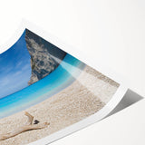 Rolled print of a serene beach landscape featuring soft waves, golden sand, and vibrant blue skies, perfect for adding a calming touch to home decor.