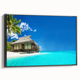 Framed canvas wall art showcasing a serene beach landscape design, with vibrant blue skies and gentle waves, presented in a sleek black frame for coastal home decor.