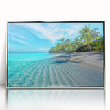 Framed wall art showcasing a serene beach landscape with soft blue waves and golden sand, elegantly displayed in a silver frame, ideal for coastal home decor.