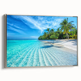 Framed canvas wall art showcasing a serene beach landscape with vibrant blue skies and golden sands, elegantly displayed with a sleek silver frame for a modern touch.
