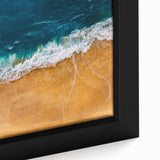 Framed canvas wall art showcasing a vibrant beach landscape with golden sands, turquoise waters, and a clear blue sky, designed to enhance any coastal-themed decor.