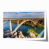 Vibrant rolled print of a serene landscape featuring a bridge over a tranquil river, ideal for home decor, showcasing nature's beauty in stunning detail.