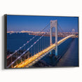 Framed canvas wall art of a serene landscape featuring a bridge over a tranquil river, with vibrant colors and a sleek black frame, ideal for home decor.